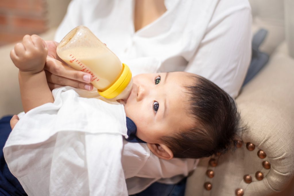 newborn-cute-baby-is-drinking-milk-from-bottle-by-mom